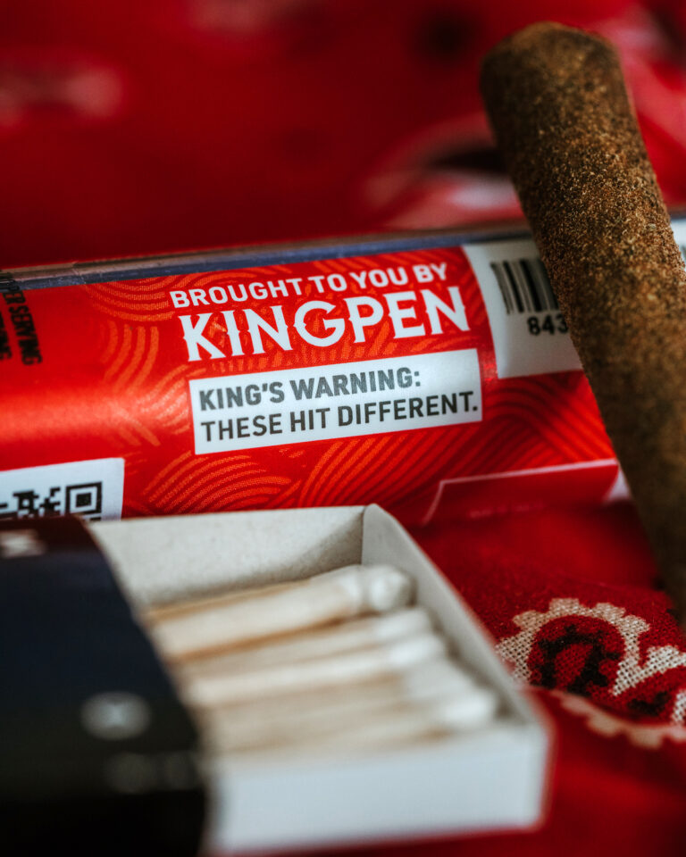 Close-up of Kingroll Pre Roll and Pre Roll case that says "Brought to you by Kingpen. King's Warning: These hit different."