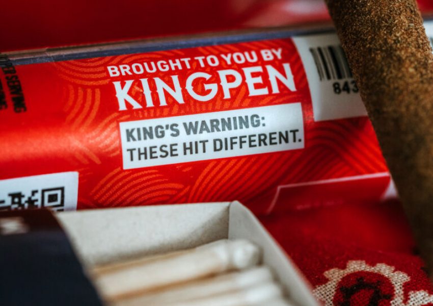 Close-up of Kingroll Pre Roll and Pre Roll case that says "Brought to you by Kingpen. King's Warning: These hit different."